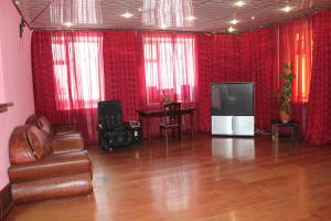 a living room with a couch and a tv at Pekin Hotel in Temirtaū