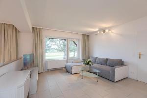 un soggiorno con divano e tavolo di Golfresidenz Wohnung B004 a Grömitz