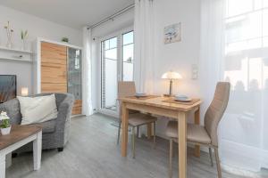 - un salon avec une table et des chaises en bois dans l'établissement Blankwasserweg 11 Wohnung 2, à Grömitz