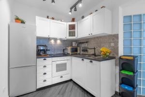 a white kitchen with white cabinets and appliances at Apartments Punat Downtown in Punat
