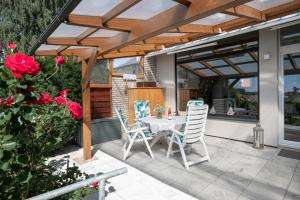 un patio con mesa, sillas y rosas en Rosengarten am Feldrand en Lenste