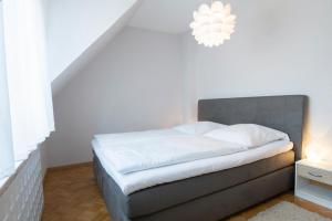 a bedroom with a bed with a gray headboard and a chandelier at Mittelweg 6 Wohnung 3 in Grömitz
