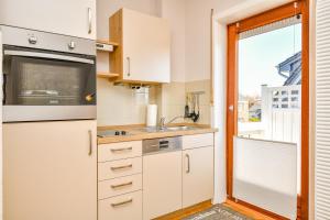 a kitchen with white cabinets and a window at Mittelweg 6 Wohnung 3 in Grömitz
