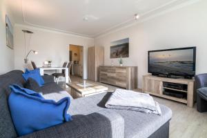 ein Wohnzimmer mit einem Sofa und einem Flachbild-TV in der Unterkunft Fürstenhof Wohnung 5 in Grömitz