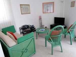 a living room with green chairs and a table at Residenz al Parco in Ascona