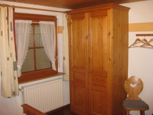 Cette chambre dispose d'une fenêtre et d'une armoire en bois. dans l'établissement Haus am Kreuzbühl, à Dachsberg im Schwarzwald