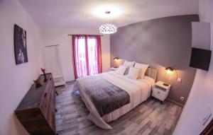 瓦朗索尔Les Chambres d Hôtes de Valensole au pays des lavandes et proche des Gorges du Verdon的带一张大床和一扇窗户的卧室