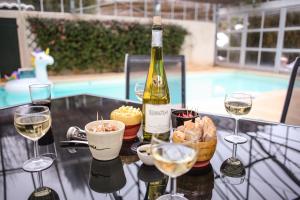 uma garrafa de vinho sentada numa mesa com copos de vinho em Les Chambres d Hôtes de Valensole au pays des lavandes et proche des Gorges du Verdon em Valensole