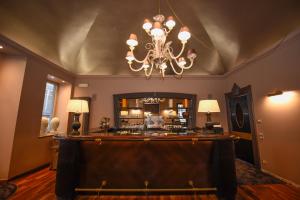 a bar in a room with a chandelier at The Tuscanian Hotel in Lucca