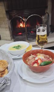 a table with a bowl of soup and a glass of beer at Olymp Hotel in Bansko