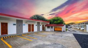 a building with a sunset in the background at Alinchlo Hotel in Legazpi