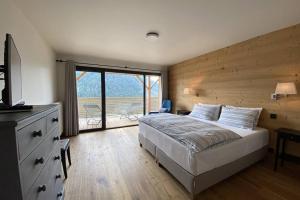 een slaapkamer met een bed met een houten muur bij Les 360 - Apt 12 - BO Immobilier in Châtel