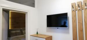 een woonkamer met een tv aan een witte muur bij Ecco Superior in Novi Pazar