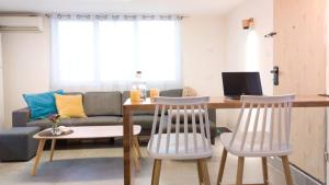 sala de estar con mesa, sillas y sofá en Primrose Boutique Apartment, en Ashdod