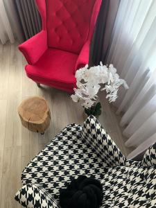 a living room with a red chair and a table at Apart Orkana 10D Zakopane in Zakopane