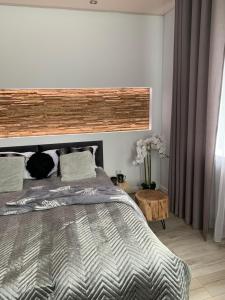 Schlafzimmer mit einem Bett mit einem Kopfteil aus Holz in der Unterkunft Apart Orkana 10D Zakopane in Zakopane