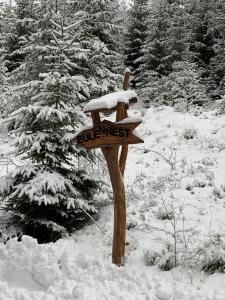 un cartello di legno nella neve in una foresta di Ferienwohnung Eulennest a Dippoldiswalde