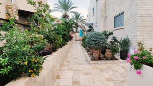 un sentiero nel giardino con piante e fiori in un edificio di Primrose Boutique Apartment a Ashdod