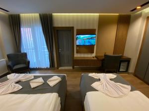 een hotelkamer met 2 bedden en een flatscreen-tv bij Sarıkamış Aras Otel in Sarıkamıs