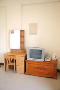 uma televisão numa cómoda de madeira ao lado de uma mesa de madeira em Yangpin House Homestay em Hualien