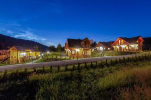 a row of houses at night with lights at Domki Bajeczny Łan in Tylicz