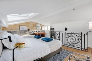 sypialnia z dużym białym łóżkiem z niebieskimi poduszkami w obiekcie Maison Labruyère Bordeaux - Jardin Public w mieście Bordeaux