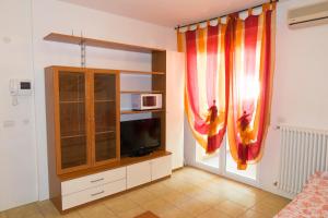 sala de estar con TV y cortina en Family Residence Nuova Orchidea, en Riccione