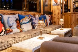 a living room with couches and tables with lamps at Hotel L'Ecrin des Neiges in La Joue du Loup +19 photos