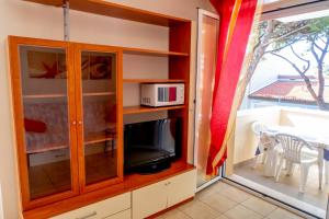 a cabinet with a microwave and a television in a room at Family Residence Nuova Orchidea in Riccione