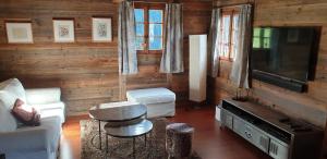 a living room with a television and a couch and a table at Chalet le Grenier - Romantique et exclusif in Champéry