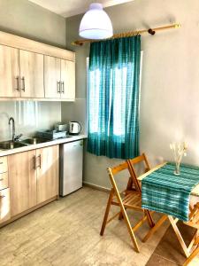 Banos Apartments and swimming pool في رودا: مطبخ مع طاولة وكراسي ومطبخ مع نافذة