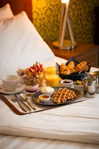 un vassoio di cibo in un letto con prodotti per la colazione di George Limerick Hotel a Limerick