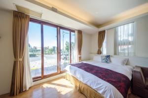 a bedroom with a bed and a large window at Lanhiwan Inn in Nanwan