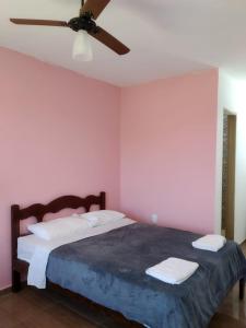 1 dormitorio con 1 cama y ventilador de techo en Renascer Suites, en Búzios