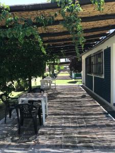 a patio with a table and chairs under a wooden pergola at Cabañas Rio Diamante in San Rafael