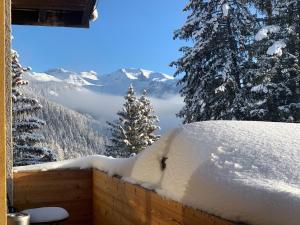 a snow covered balcony with a view of the mountains at Hôtel de charme la Poste in Anzère