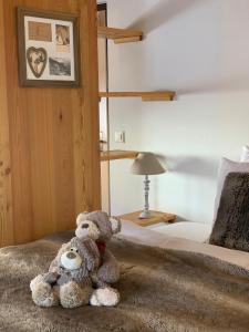 un orsacchiotto seduto sopra un letto di Hôtel de charme la Poste ad Anzère