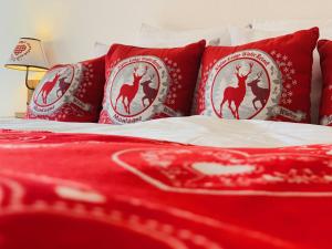 - un lit avec des oreillers et une couverture rouges dans l'établissement Hôtel de charme la Poste, à Anzère