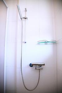 a shower with a hose attached to a wall at Yangpin House Homestay in Hualien City