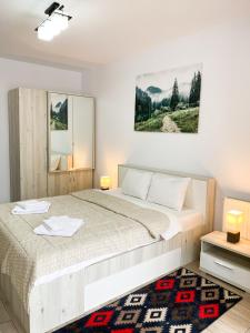 Habitación blanca con cama y espejo en Forest View Oasis, en Brasov