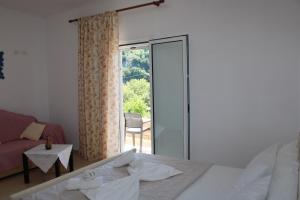 a bedroom with a bed and a sliding glass door at PENELOPE 2 in Dhërmi +8 photos