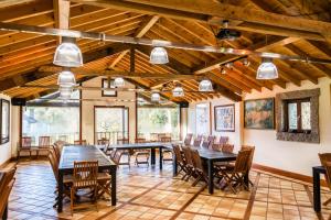 a large room with wooden ceilings and tables and chairs at Entre Os Ríos - Casa Rural y Enoturismo in A Pobra do Caramiñal
