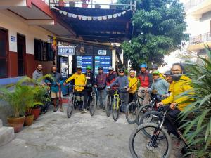 un groupe de personnes à vélo devant un bâtiment dans l'établissement Pokhara Youth Hostel, à Pokhara