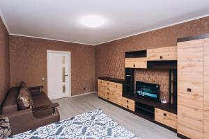 Un dormitorio con una cama y un televisor en una habitación. en The Cool Home Лавина пр М Лушпы 5 корпус 27, en Sumy
