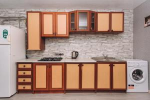 cocina con armarios naranjas y nevera blanca en The Cool Home Лавина пр М Лушпы 5 корпус 27, en Sumy