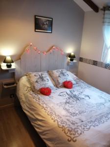 um quarto com uma cama com almofadas vermelhas em gite proche etretat em Tourville-les-Ifs
