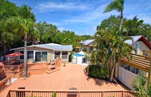 a deck with palm trees and a house at Siesta Heron Suites & Villas in Siesta Key