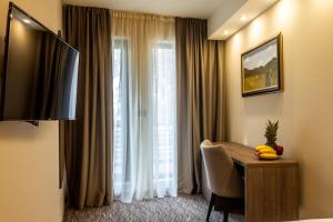 una camera d'albergo con tavolo e finestra di NEW Garni Hotel FILIA a Nova Pazova