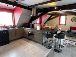 - une cuisine avec un comptoir et des tabourets dans une pièce dans l'établissement P'tit Biscuit, à Riquewihr