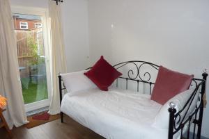 a bedroom with a bed with red pillows on it at A wonderful place in the hub of the city, yet on the edge of the countryside in Salisbury